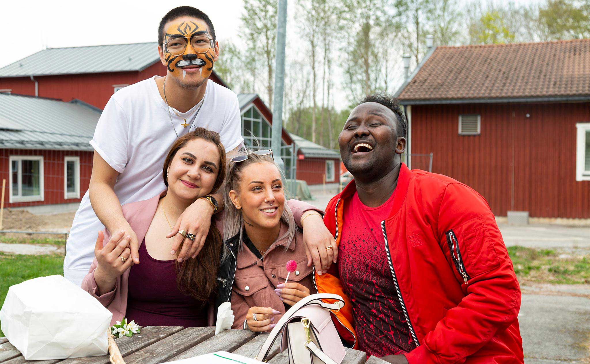 Elever utanför Kävesta folkhögskola, en är målad som en tiger, en har en godisklubba.
