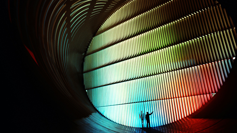 Industribild med mörka partier och färgglatt ljus