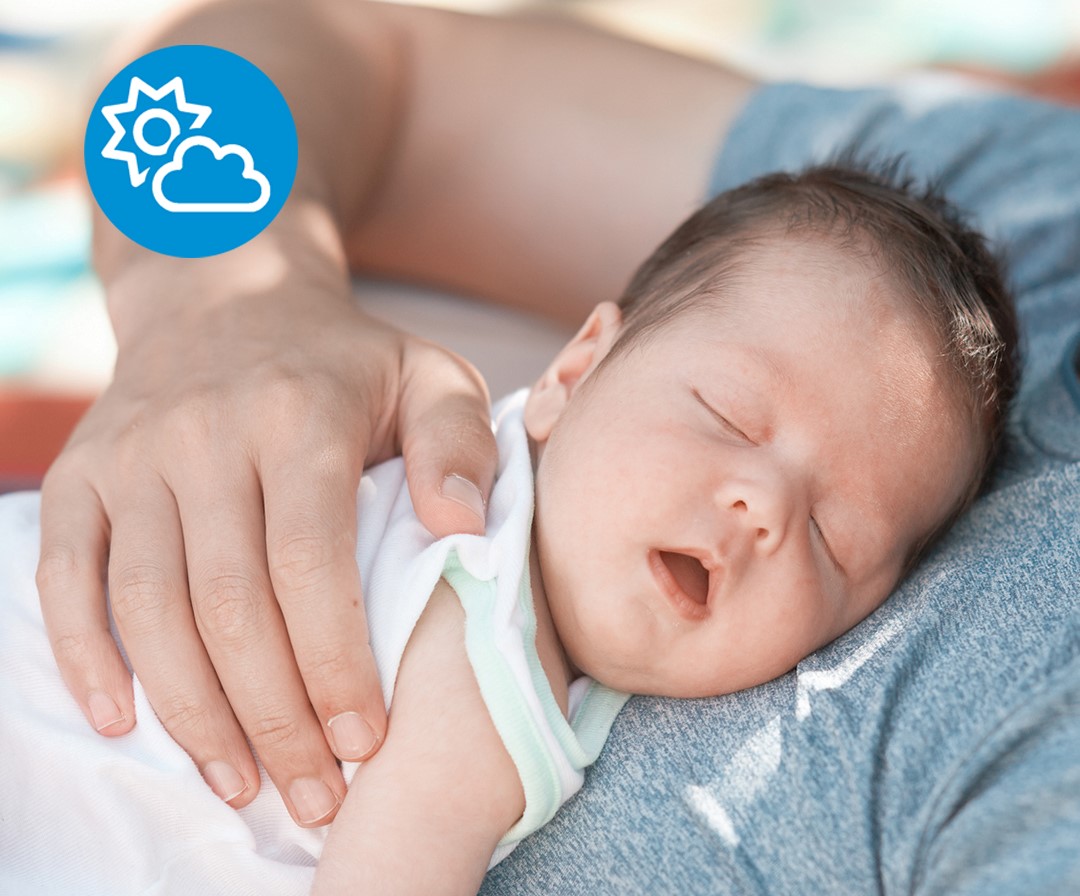 Bebis ligger i förälders famn och sover