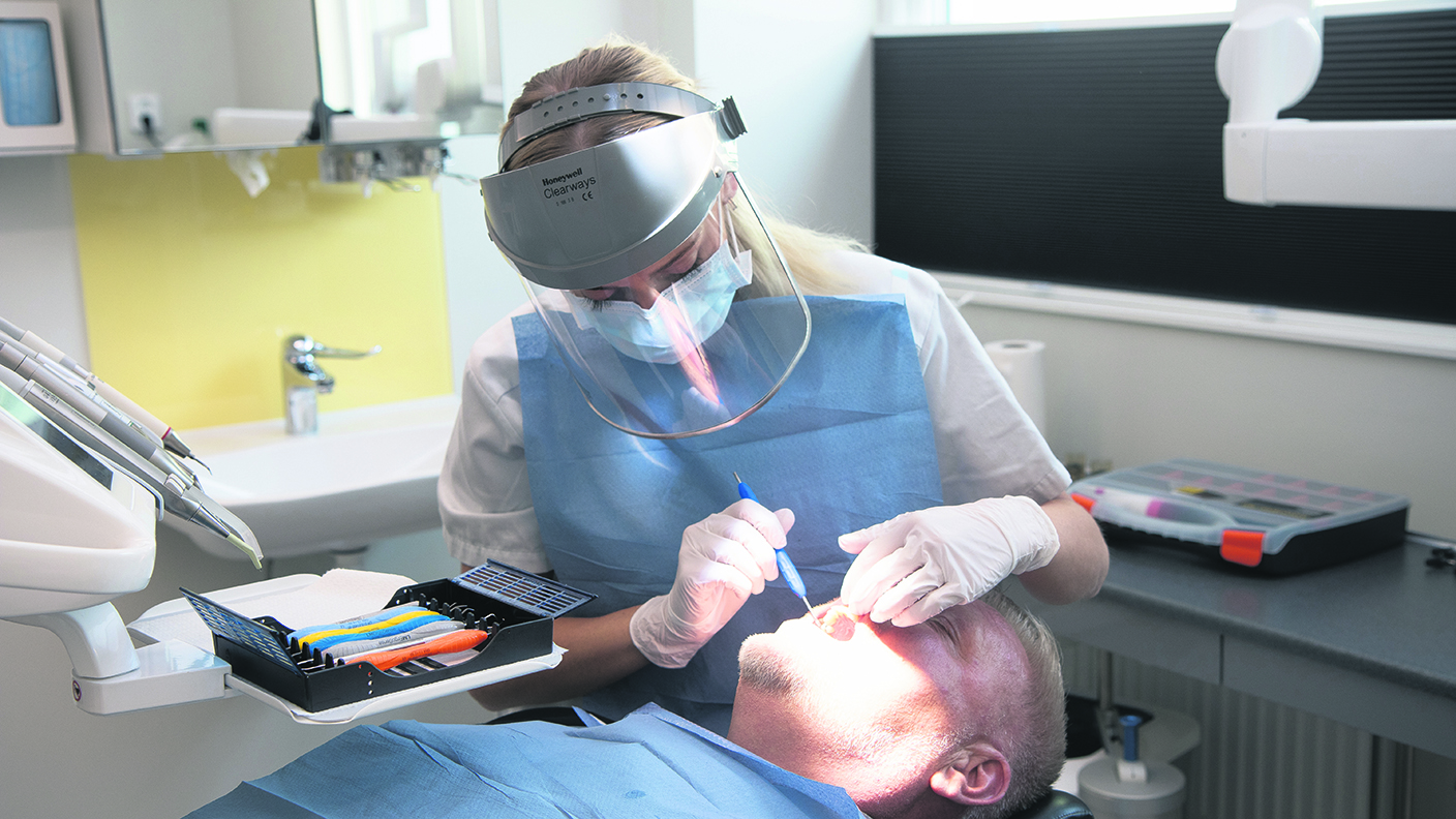 En tandhygienist undersöker en patient.