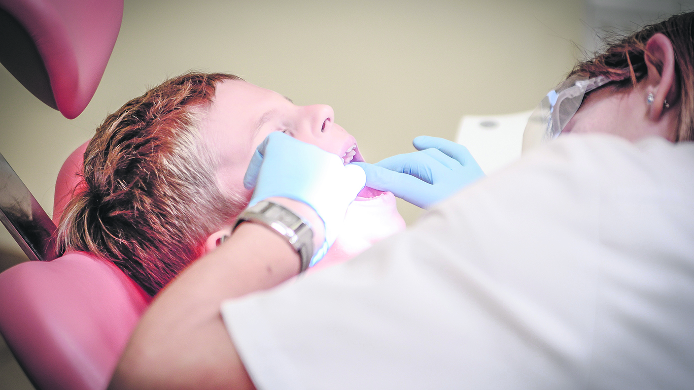 En tandläkare undersöker ett barns tänder.