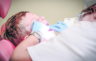 En tandläkare undersöker ett barns tänder.