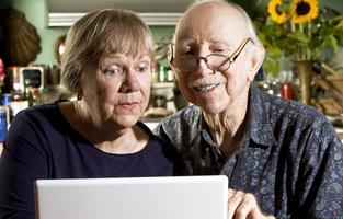 Äldre par med dator.