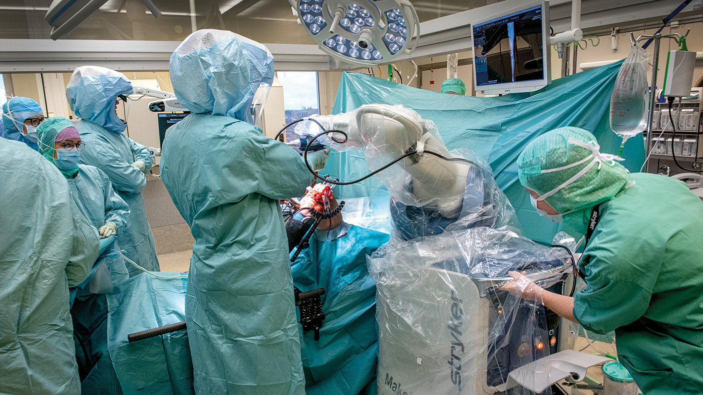 Sjukvårdspersonal ställer in operationsroboten.