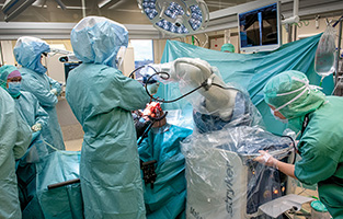 Sjukvårdspersonal ställer in operationsroboten.