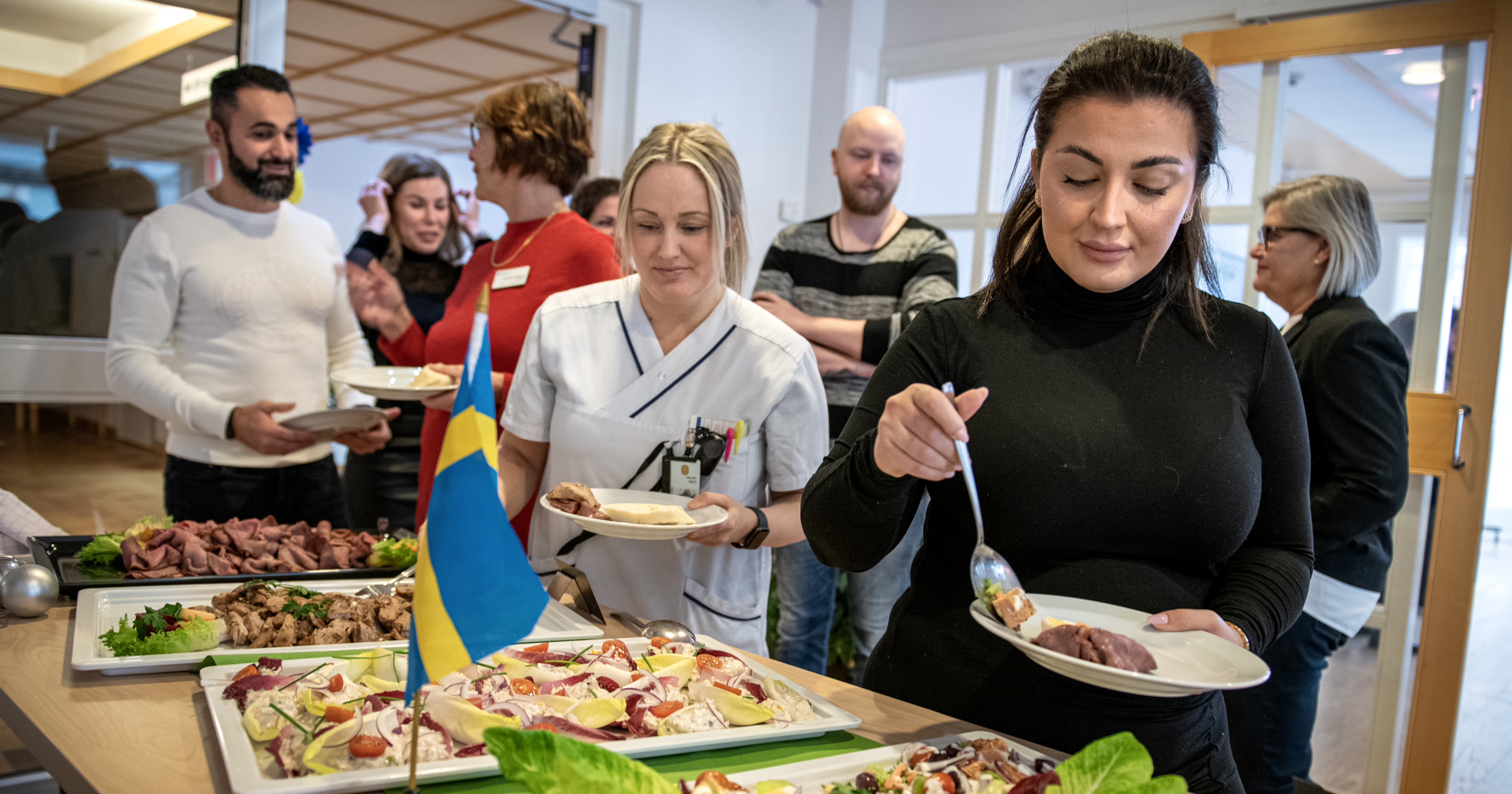 Personer tar mat vid lunchbuffé