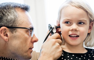 En läkare undersöker ett barns öra.