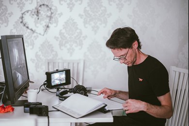 Jonas Moberg sitter framför en datorskärm arbetar med filmklippning