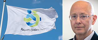 Hälso-och sjukvårdsdirektör Jonas Claesson bredvid Region Örebro läns flagga