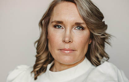 Porträttfoto av kvinna med  axellångt mellanblont hår och blå ögon
