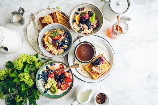 Uppdukat frukostbord med skålar fyllda med frukt och bär