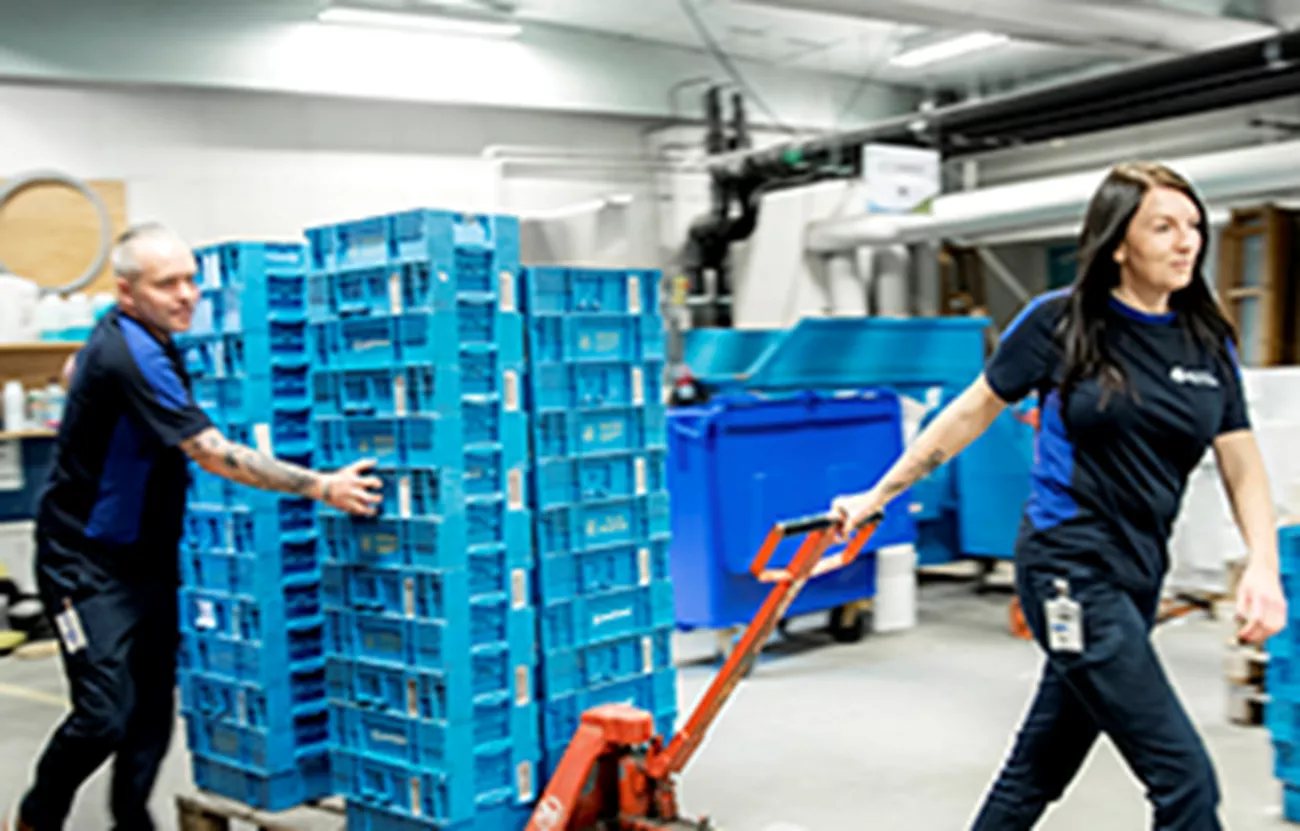 Två personer på vaktmästeriet som flyttar gods