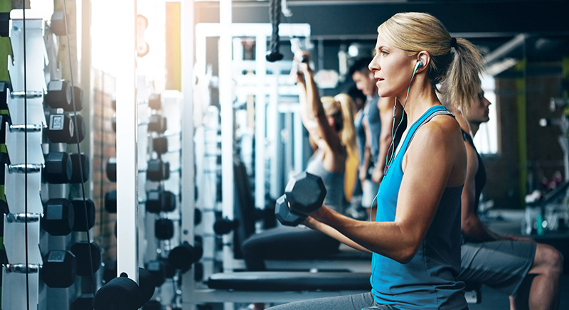 Kvinna som tränar på gym med hantlar